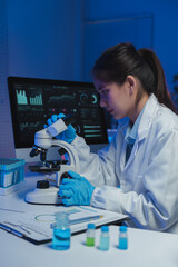 Female scientist wearing lab coat and gloves using microscope, working with graphs and test tubes...