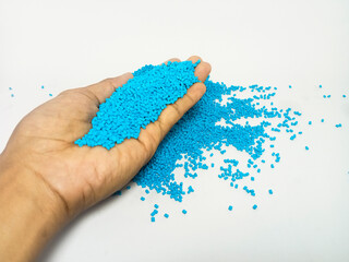 blue masterbatch, polymer carrying pigment in hand grip isolated on white background, suitable for industrial plastic company profile product catalog design