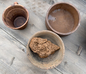 A bowl of food sits on a table next to a cup and a bowl of water