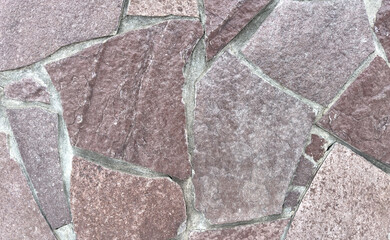 A stone wall with a lot of cracks and holes