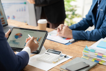 Data-Driven Decisions: A team of professionals engaged in a business meeting, analyzing data on a tablet and paper documents.