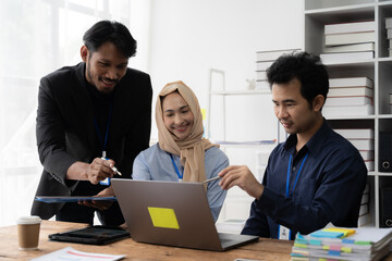 Collaborative Brainstorming: A diverse team of professionals engages in a collaborative brainstorming session, examining ideas and strategies on a laptop.