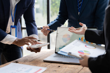 Business Professionals Analyzing Data: A team of diverse business professionals collaborates around a laptop, analyzing data and charts.