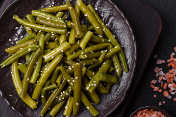 Steamed green beans on a plate with olive oil, sesame seeds