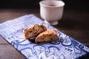 Cantuccini (Italian cookies) and a cup of coffee on dark wooden background. Close up..	