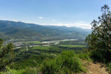 Valley and river Mtkvari (Kura), view from above from the hill. Green meadows, mountains, blue sky, village houses. © Michael