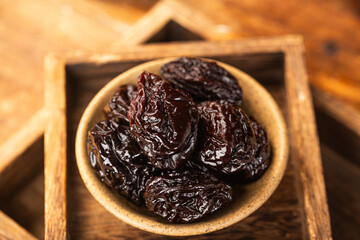 There are dried plums and dried sweet fruit preserves on the table
