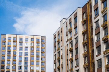 Fototapeta premium A low-angle shot of several modern apartment buildings on a sunny day under a blue sky.