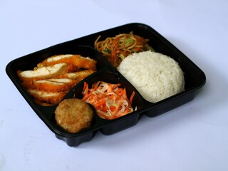 Katsu chicken, rice, noodles, mashed potatoes, vegetable salad, and fritter served on bento box meal isolated white, copy space. Suitable for students and busy worker, home business opprtunity