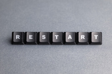 Restart word, arranged with computer keyboard buttons on gray background