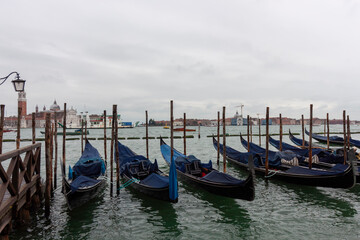 Gondolas moored on the water in Venice, Italy, with the cityscape and the Campanile di San Giorgio Maggiore in the background © virin