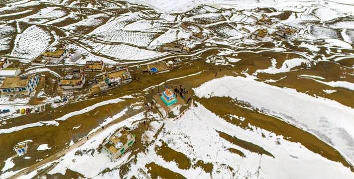 drone image of Himalayan langza village with snow-covered rooftops and surrounding hills