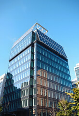 Modern office building with glass facade and solar panels on roof, sustainable architecture design