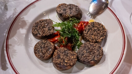 Ración de deliciosa morcilla de arroz frita con pimientos rojos en un restaurante