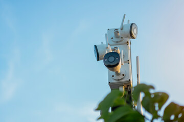 A CCTV camera hanging on a outdoor pol and recording.