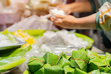 Thai street food seller at the night market in Chiang Mai, Thailand. Selective focus on a local snacks