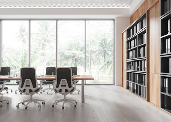 Modern office interior with large windows, meeting table, and shelving unit in a bright open space surrounded by greenery outdoors. 3D Rendering