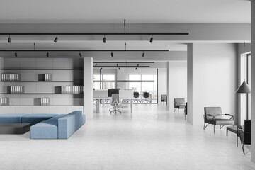 Modern open-space office interior with minimalist furniture and large windows overlooking the...
