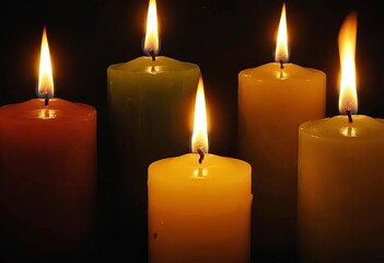 A close-up of lit candles in a dark room