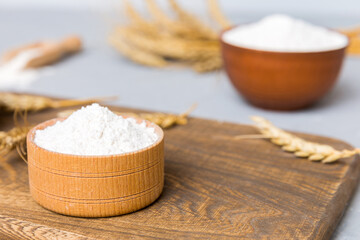 Flat lay of Wheat flour in wooden bowl with wheat spikelets on colored background. world wheat crisis