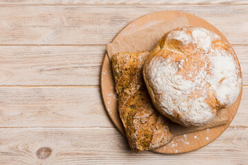 Freshly baked bread on cutting board against white wooden background. top view bread with copy space