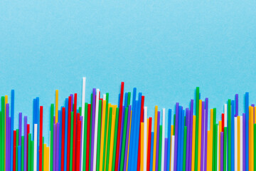 Heap of colorful plastic drinking straws on Colored background, flat lay. Copy Space for text