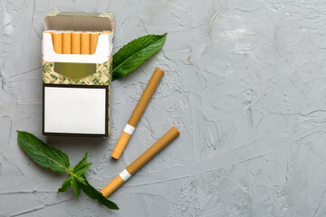 Pack of menthol cigarettes and fresh mint on colored table, Menthol cigarettes top view flat lay