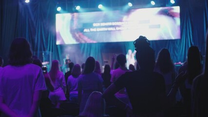 Christian Believers with Raised Hands Sing on Music Live Concert or Show Event with Lights. Young People Worship and Praise on Festival or Conference