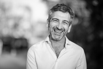Smiling man in black-and-white portrait outdoors