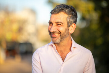 Fototapeta premium Cheerful man looking sideways outdoors with natural background