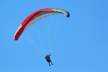 Paraglider flying in a blue sky
