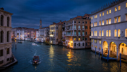 Grand Canal of Venice illuminated at dusk showcasing stunning architecture and serene boat travel seen from the Rialto Bridge