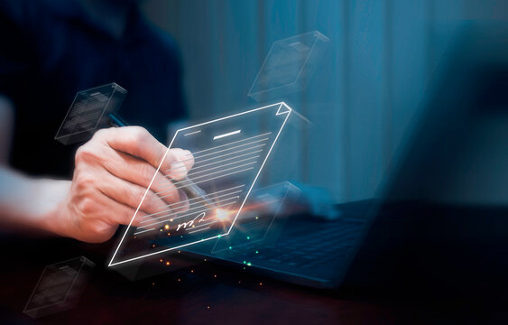 Electronic signature and paperless concept. Businessman uses a pen to sign electronic documents on digital documents on a virtual screen.