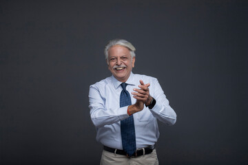 Male Senior Citizen Smiling and Clapping With Both Hands