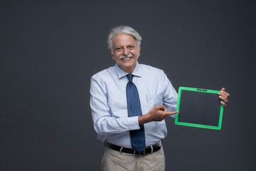 Wealthy Senior Man Pointing His Finger On The Black Slate