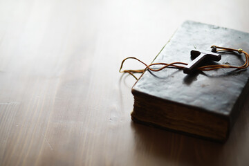 Vintage Bible with Wooden Cross Necklace on Wooden Surface - Religious Symbolism and Faith
