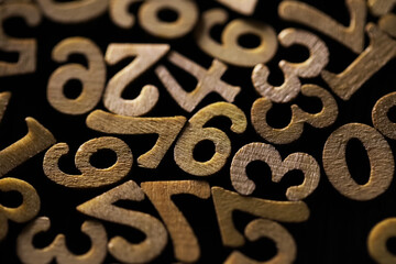 Close-Up of Wooden Numbers in Random Pattern on Dark Background
