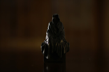 Mysterious Hooded Figure in Dark Cloak - Dramatic Silhouette of Shrouded Statue with Shadows