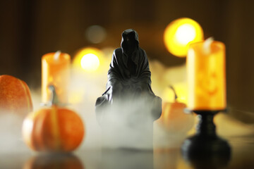 Spooky Hooded Figure Amidst Pumpkins and Fog with Glowing Candles - Halloween Atmosphere