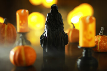 Halloween Decor with Hooded Figurine, Pumpkins, and Spooky Candles
