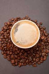 Paper cup with coffee on roasted coffee beans	