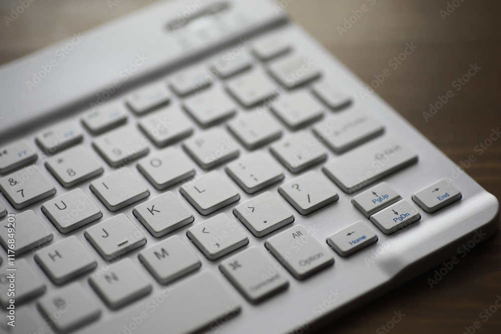 Poster close-up of modern white computer keyboard with blue function key on wooden desk