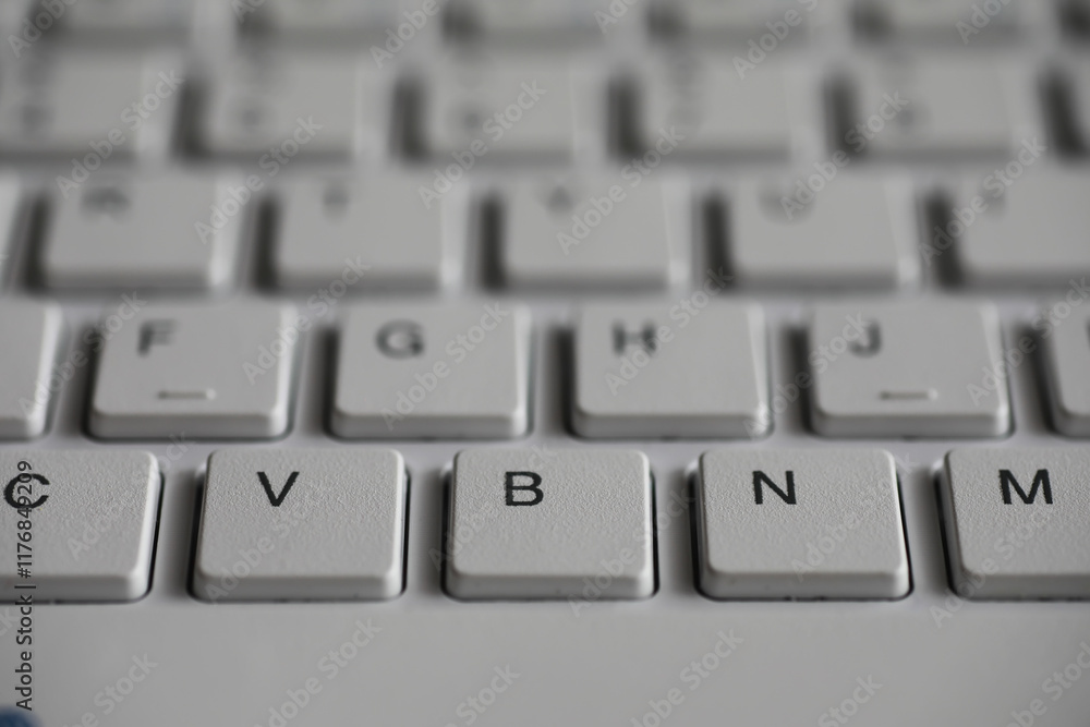 Poster close-up shot of a keyboard with focus on v, b, and n keys in a monochromatic scheme