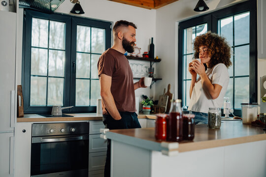 Happy couple enjoying morning coffee in modern kitchen