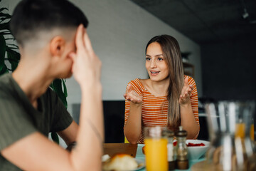 Lesbian couple having breakfast and discussing at home