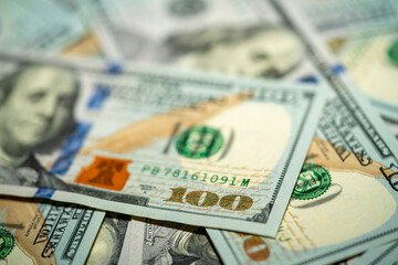 Close up view of scattered hundred dollar bills on a surface