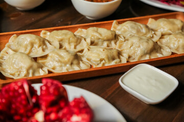 Delicious dumplings served with dipping sauce on a wooden platter