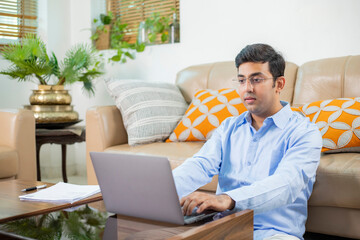 Adult Male In Blue Shirt Using Laptop While Sitting On The Floor At Home