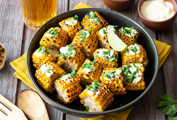 Grilled corn with white sauce and herbs. BBQ. Picnic. Vegetarian food. Diet.
