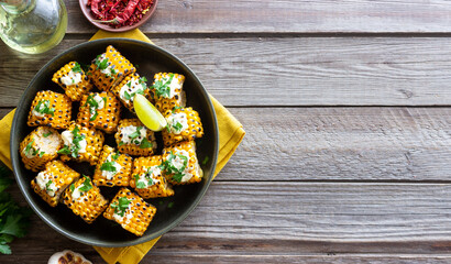 Grilled corn with white sauce and herbs. BBQ. Picnic. Vegetarian food. Diet.